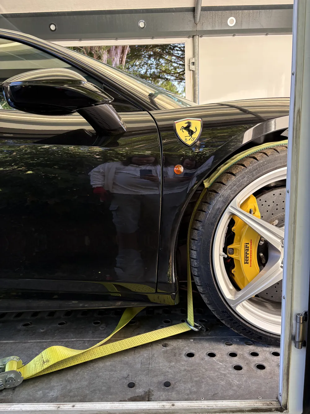 Ferrari wheel strapped and secured inside the enclosed trailer