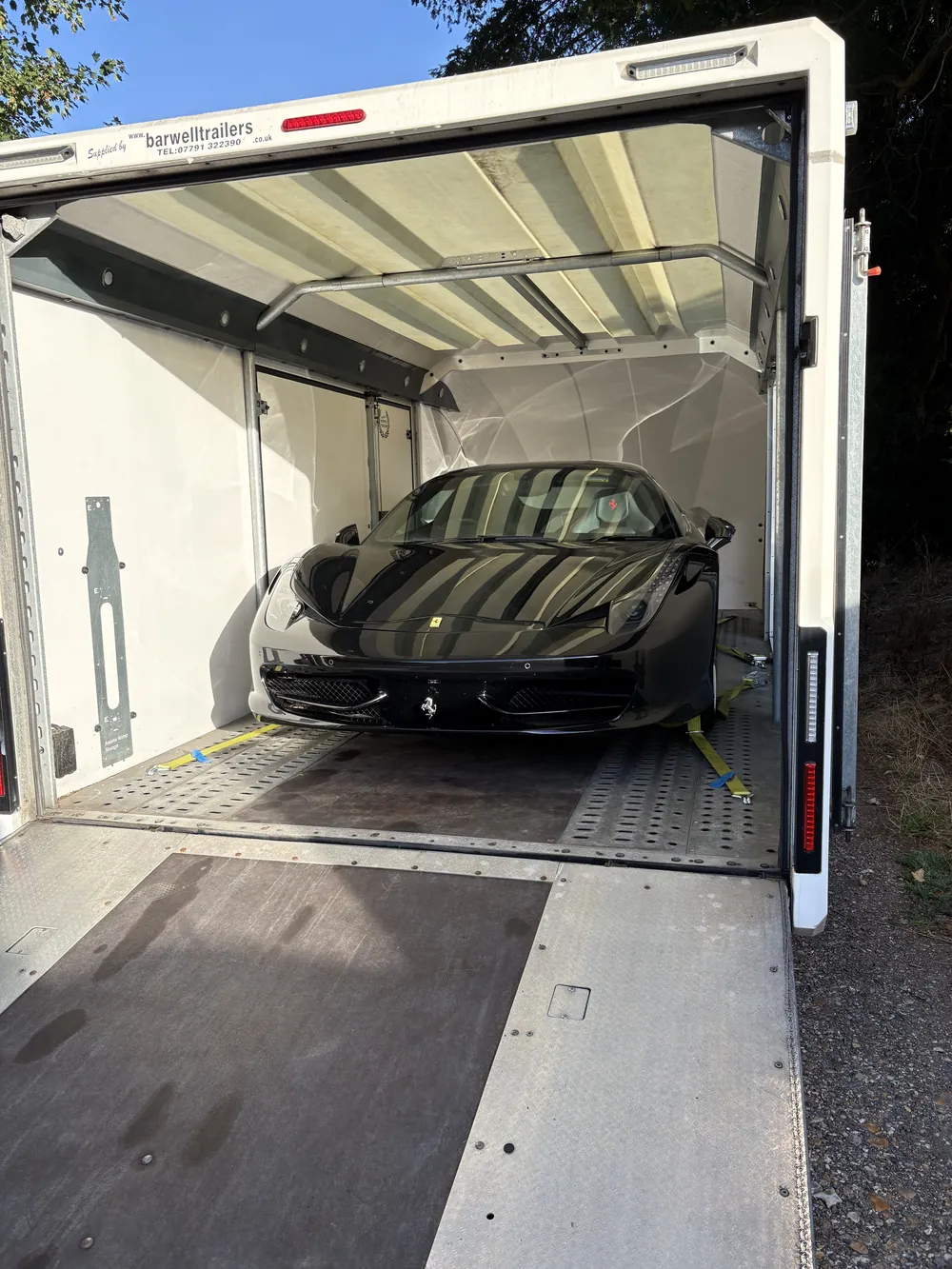 Ferrari head-on inside the enclosed trailer before the doors close