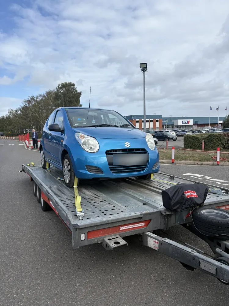 Small hatchback loaded on the trailer at a retail park