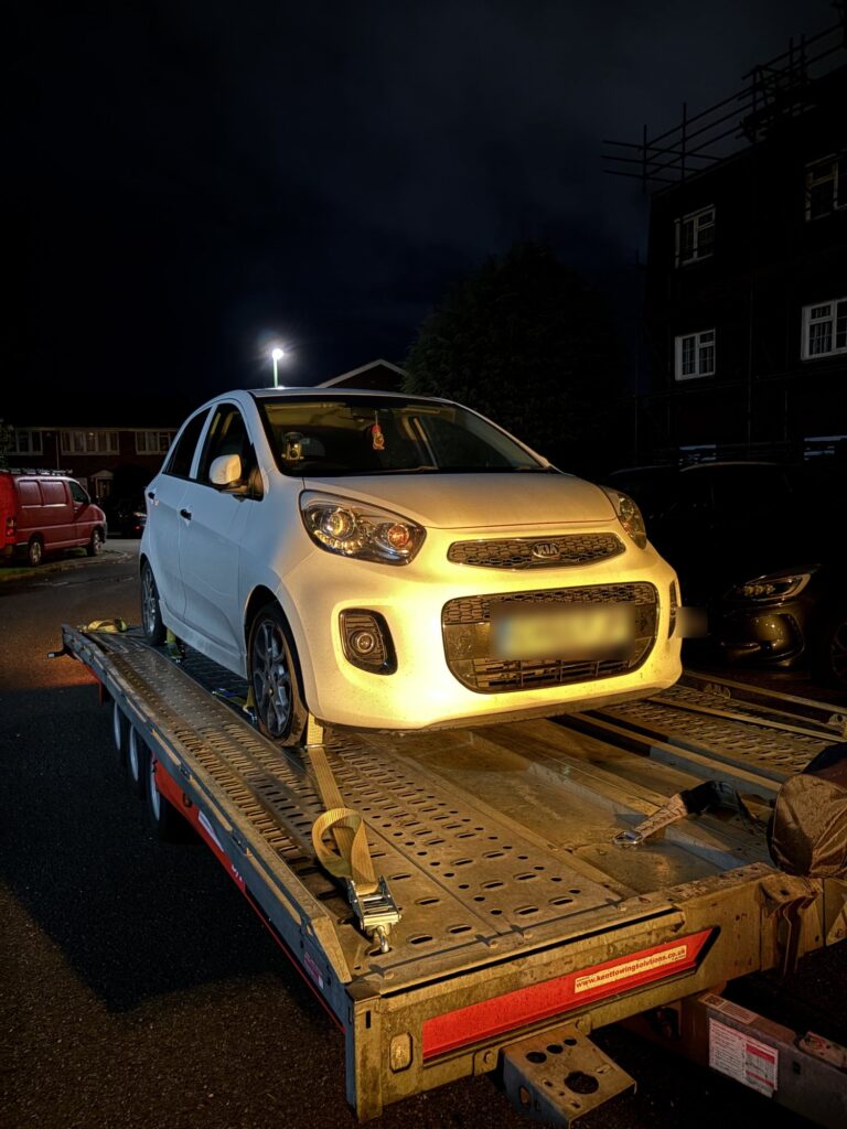 White Kia Picanto loaded onto the Timeless Transport trailer during a night-time breakdown recovery